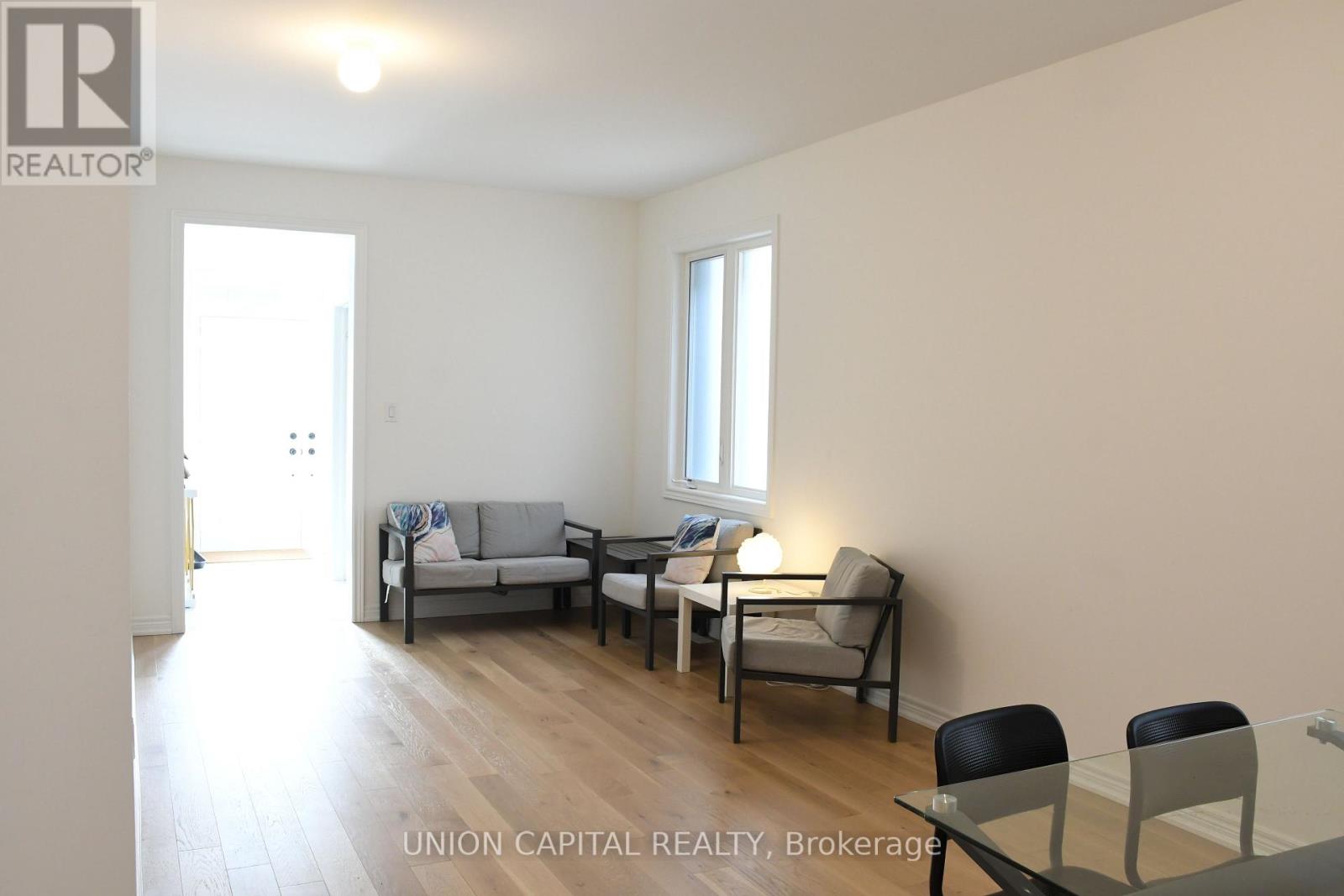 A living room with a couch, chairs, and a dining table.