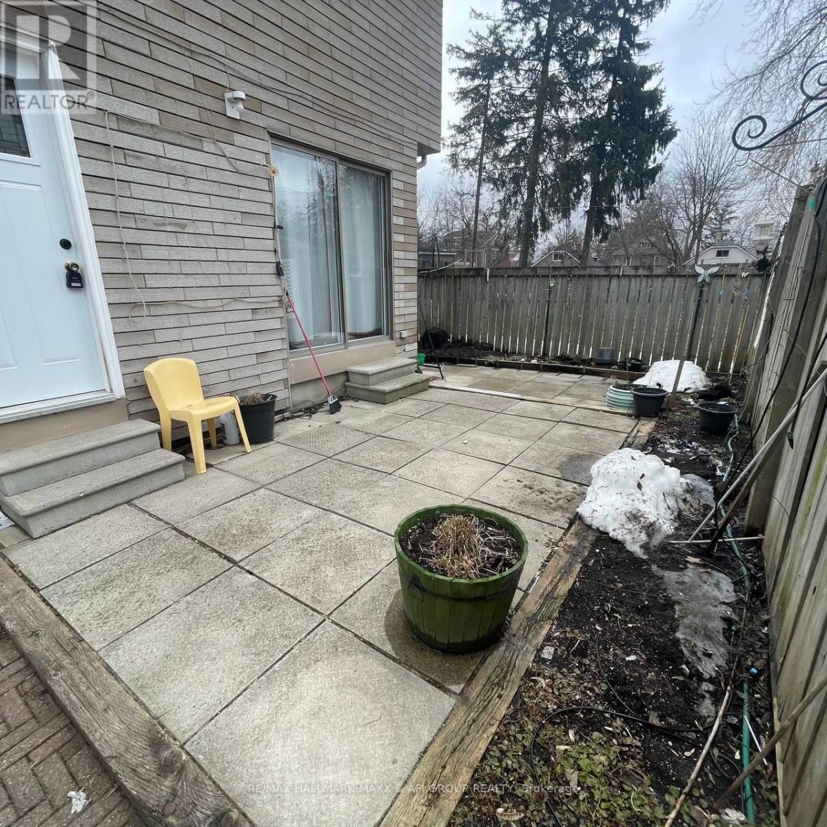 A patio with a yellow chair and a green planter.