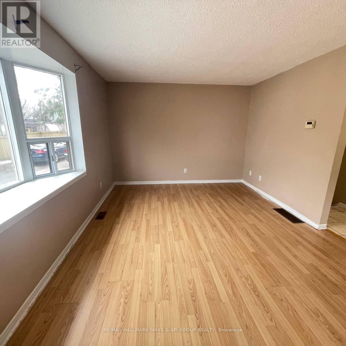 A room with wooden flooring and a window.
