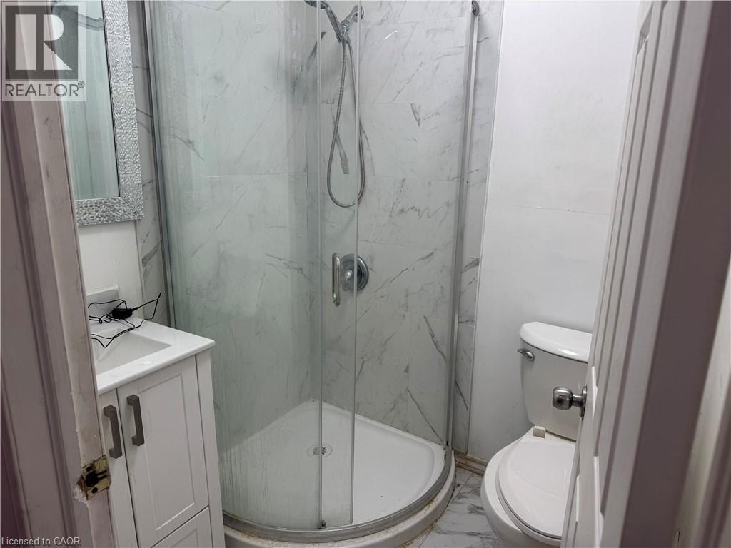 A bathroom with a white toilet and a walk in shower.