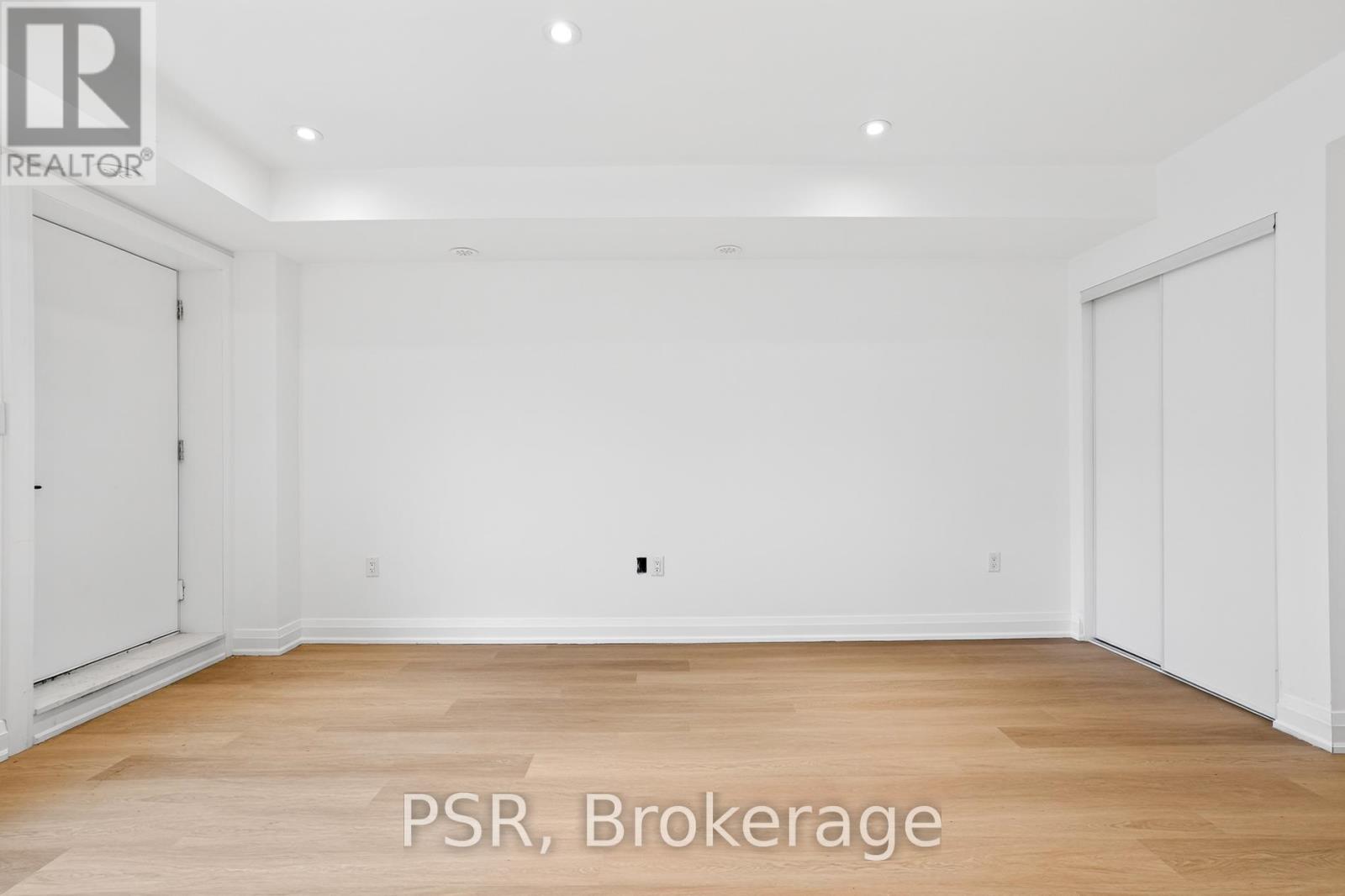 A large, empty room with wooden floors and white walls.