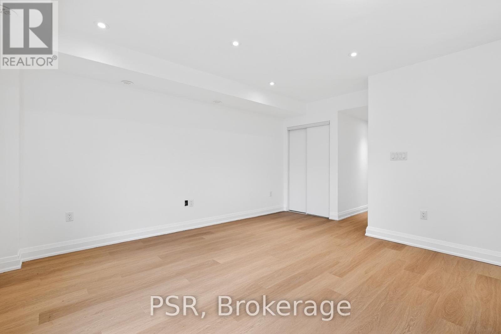 A large empty room with wooden floors and white walls.