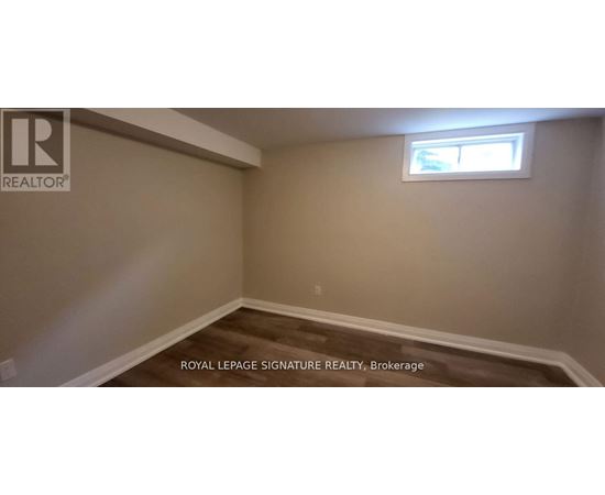 A room with a window and wooden flooring.