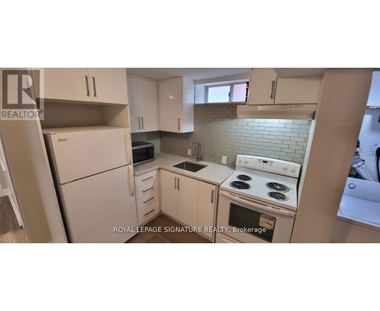 A white kitchen with a stove top oven and a microwave.