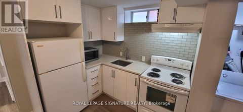 A white kitchen with a stove top oven and a microwave.
