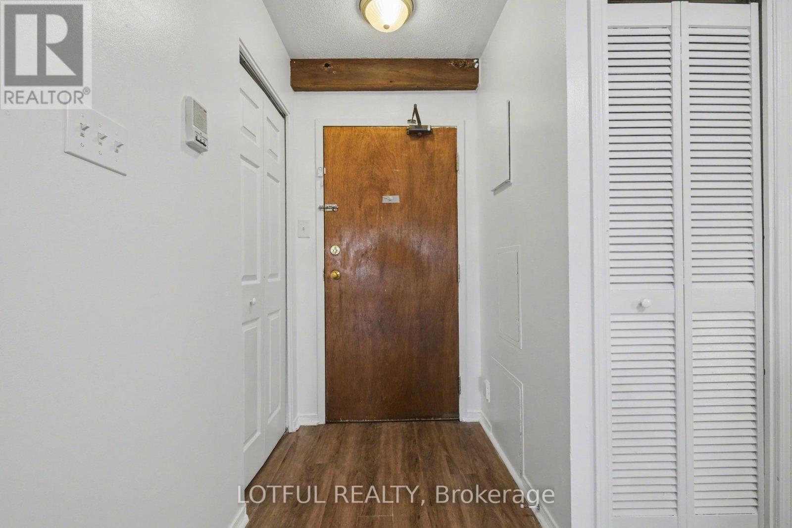 A hallway with a wooden door and white walls.