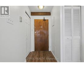 A hallway with a wooden door and white walls.