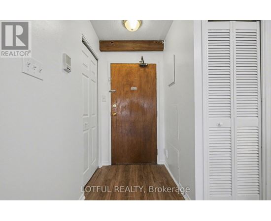 A hallway with a wooden door and white walls.