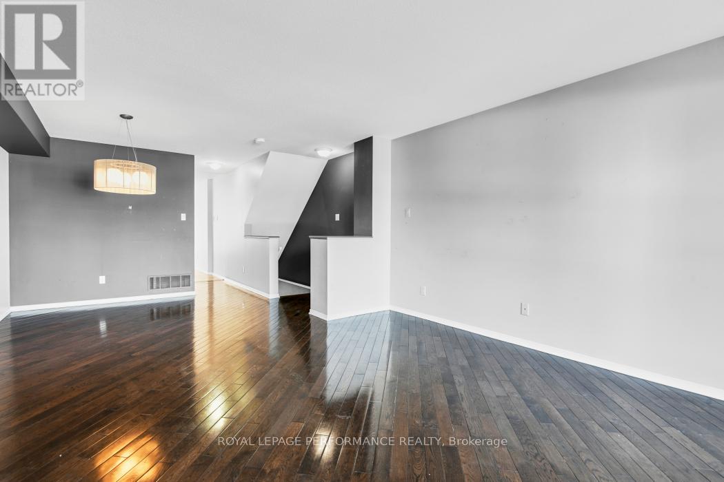 A spacious room with wooden floors and white walls.