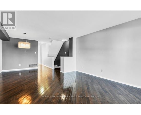 A spacious room with wooden floors and white walls.