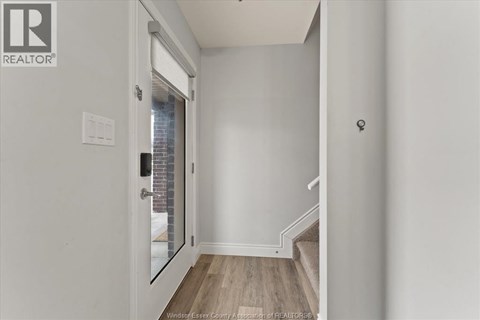 A kitchen with white cabinets and a black fridge.