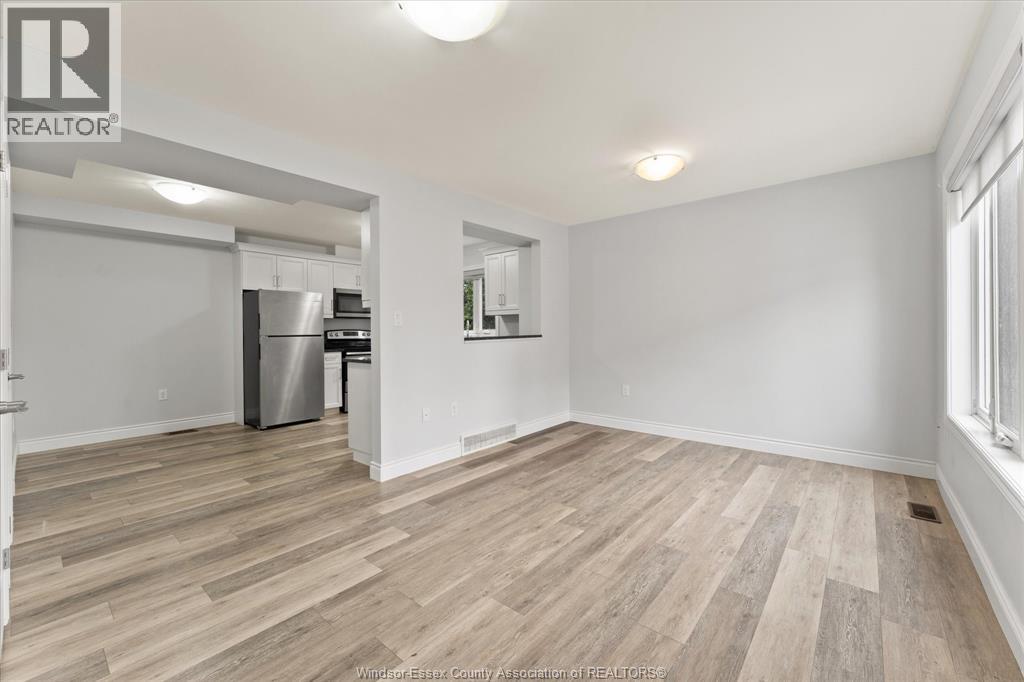 A room with a vacuum cleaner on the wooden floor.