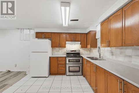 A kitchen with wooden cabinets and a white refrigerator.