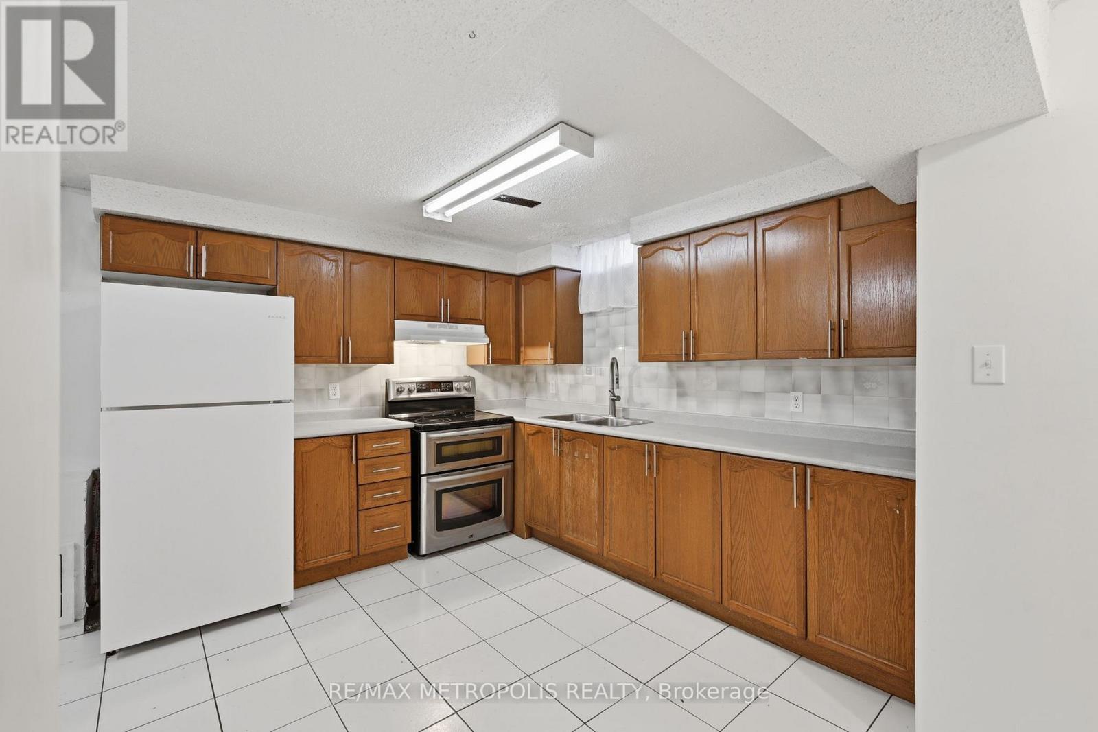 A kitchen with white appliances and wooden cabinets.