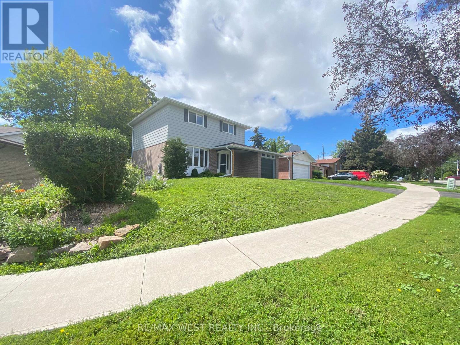 A house with a lawn and a sidewalk in front of it.
