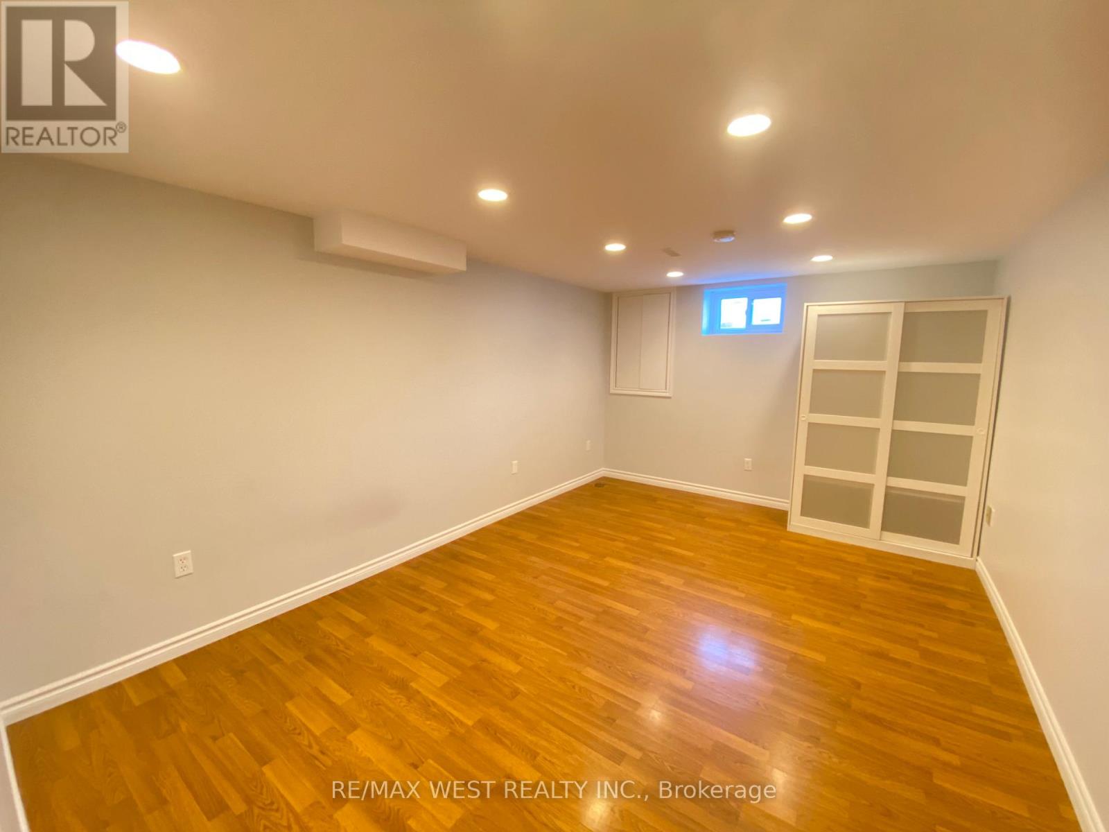 A room with wooden flooring and a window with blinds.