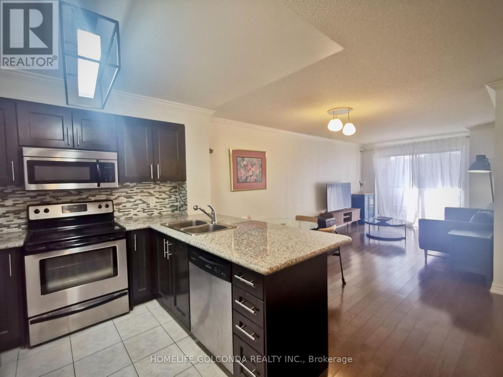 A kitchen with dark wood cabinets and stainless steel appliances.