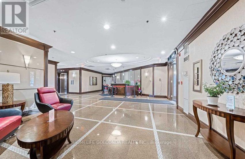 A spacious lobby with a red chair, a wooden table, and a mirror on the wall.
