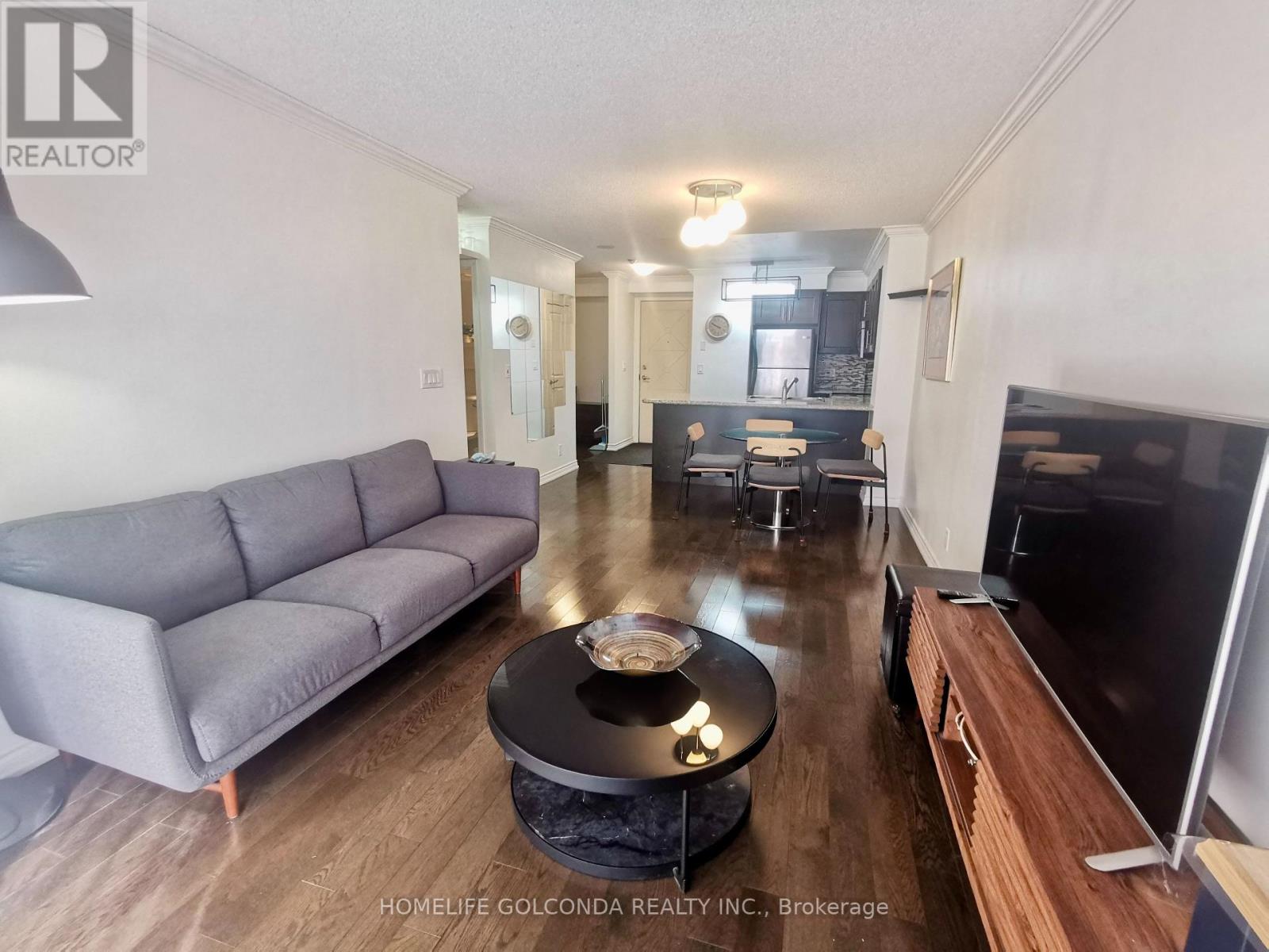 A living room with a grey couch and a black coffee table.