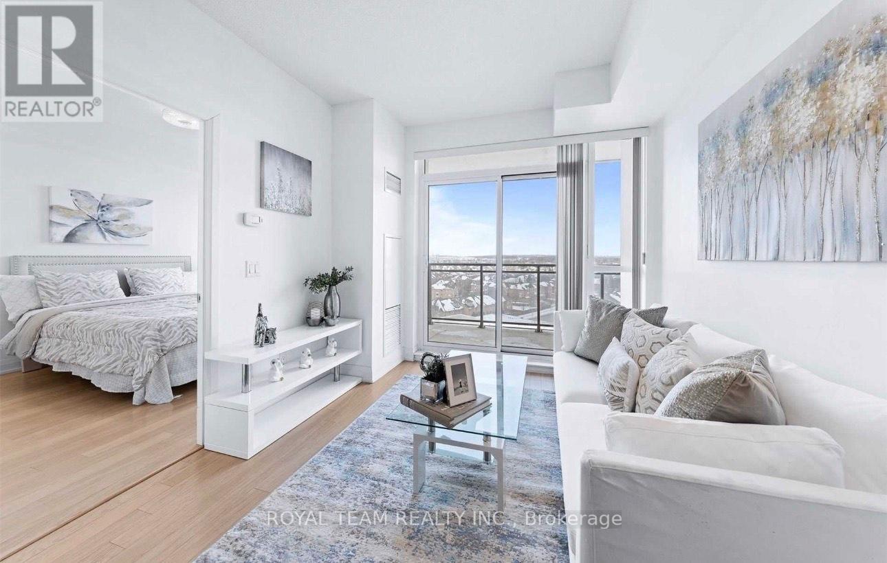 A well-lit, spacious bedroom with a large bed and a view of the city through the window.