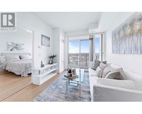 A well-lit, spacious bedroom with a large bed and a view of the city through the window.