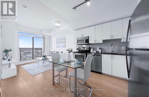 A modern kitchen with a glass table and stainless steel appliances.