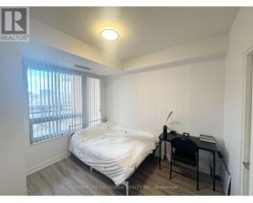 A bedroom with a bed, desk, and chair.