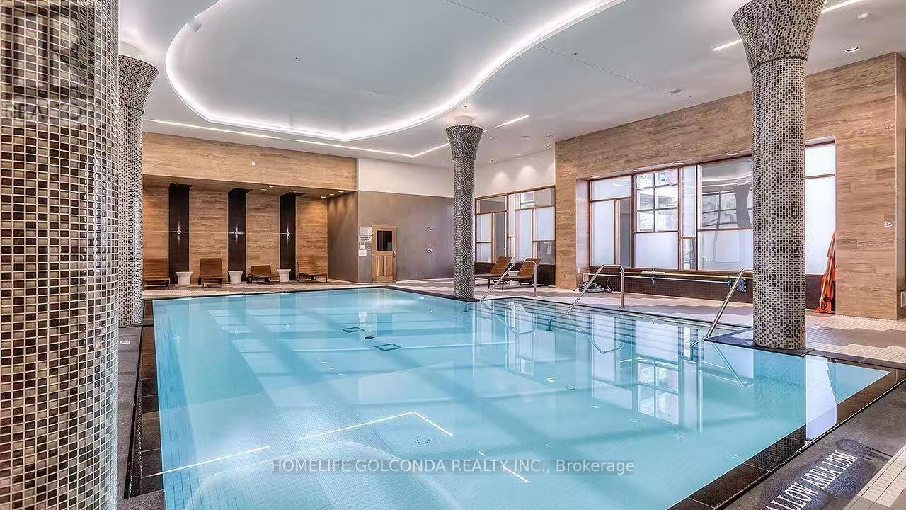 A large indoor swimming pool with a tiled wall on the left side.