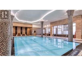 A large indoor swimming pool with a tiled wall on the left side.