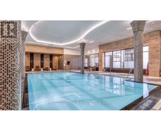 A large indoor swimming pool with a tiled wall on the left side.