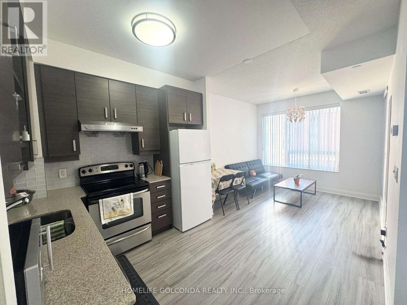A modern kitchen with a stove top oven and a refrigerator.