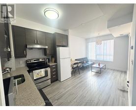 A modern kitchen with a stove top oven and a refrigerator.