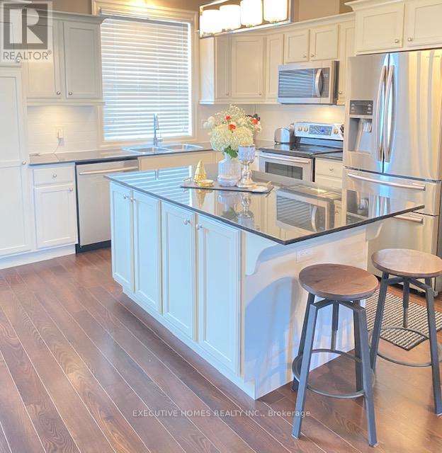 A kitchen with a white island and a refrigerator.