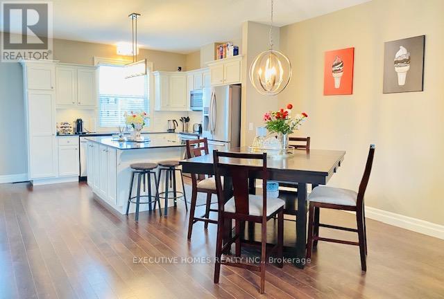 A kitchen with a table and chairs in front of it.