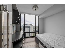 A bedroom with a large bed and a balcony overlooking the city.
