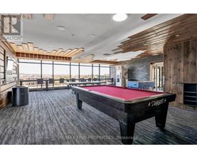 A pool table in a room with wooden walls and ceiling.