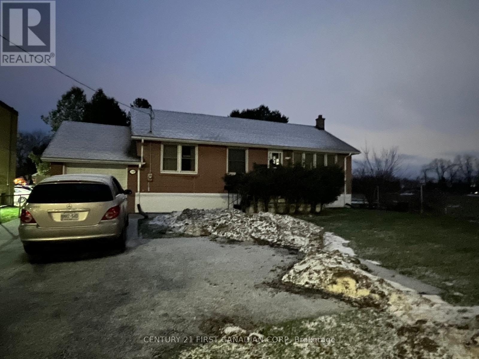 A house with a car parked in front of it at night.