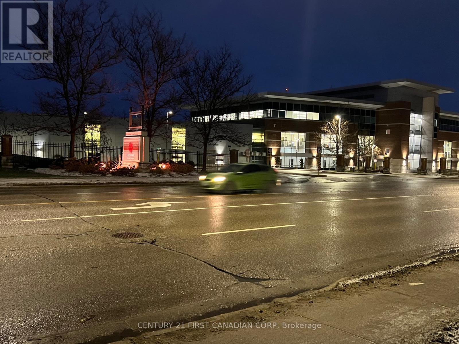 A car is driving past a building with the words "Century 21 First Canadian Corp. Brokerage" on it.