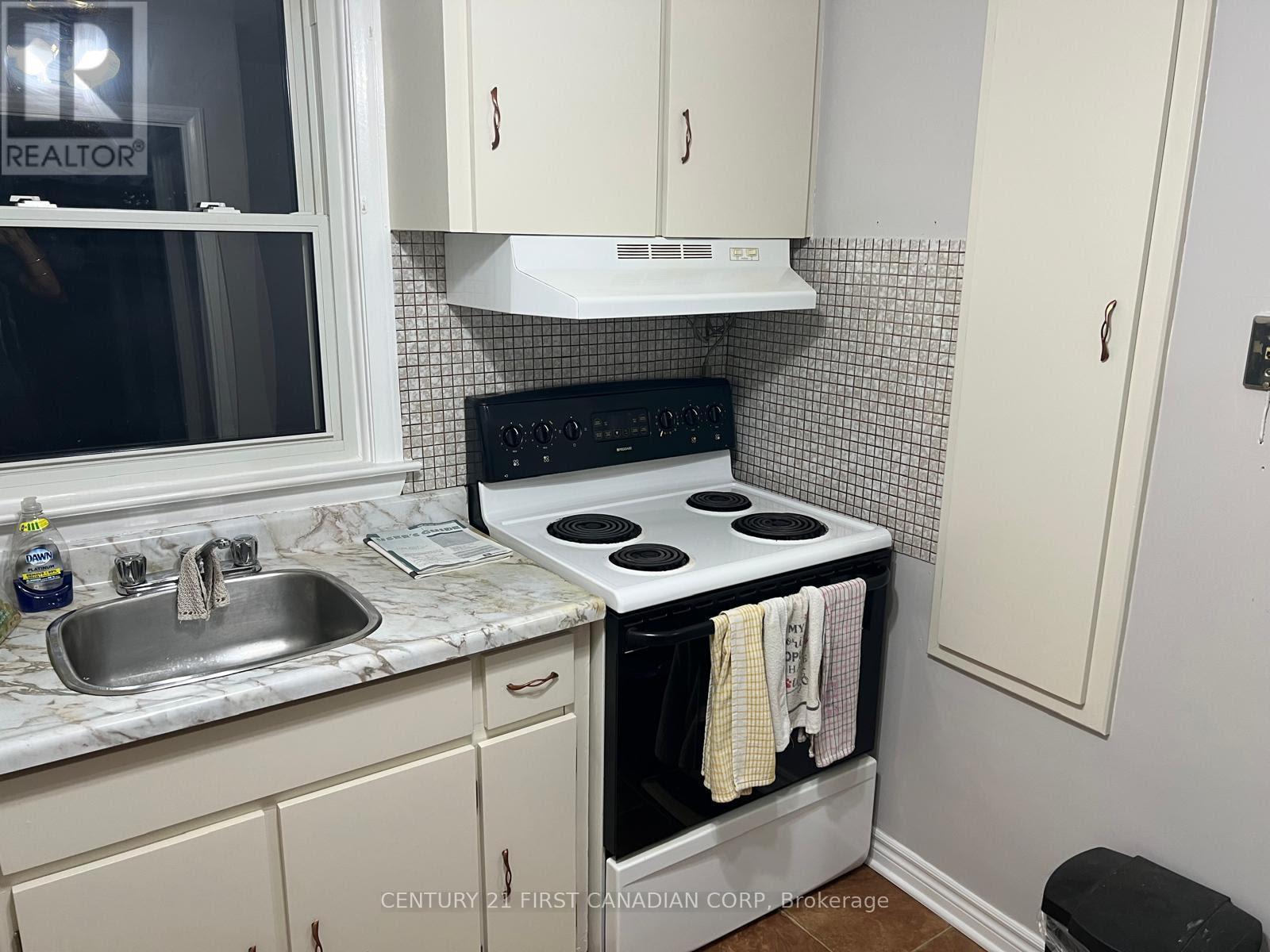 A kitchen with a stove and sink.