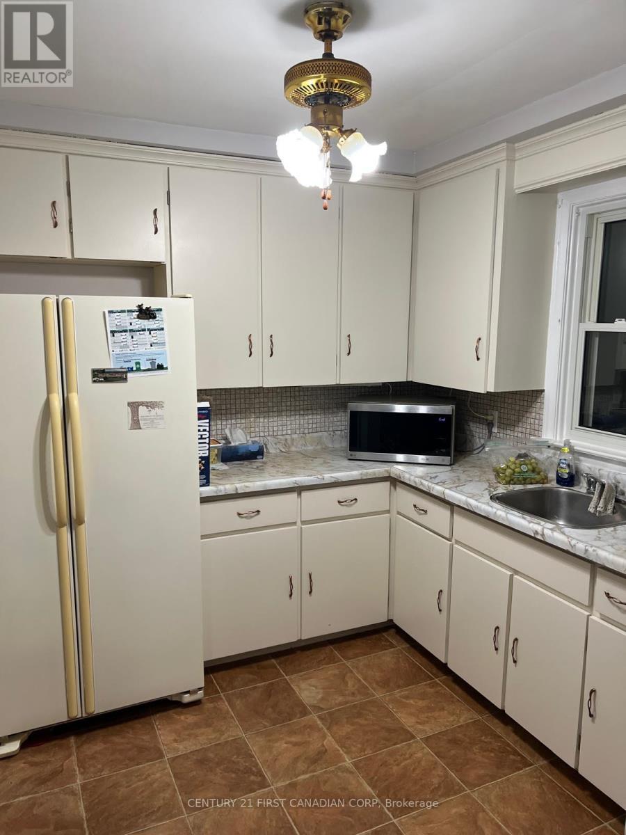 A kitchen with white cabinets and a white fridge.