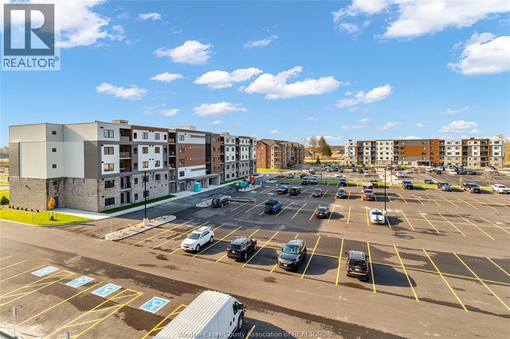 A parking lot with cars and apartment buildings in the background.