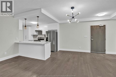 A spacious kitchen area with a white counter and a ceiling fan.