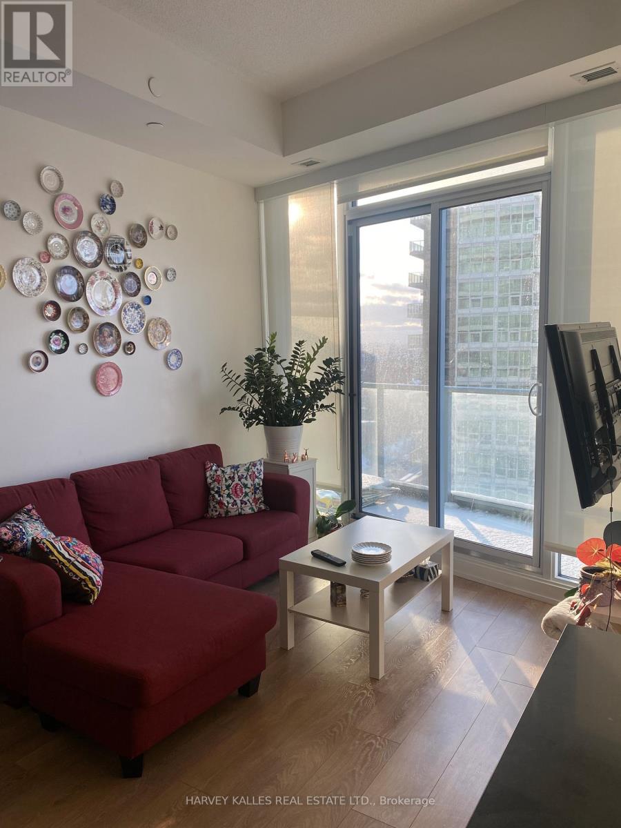 A living room with a red couch and a wall decorated with plates.