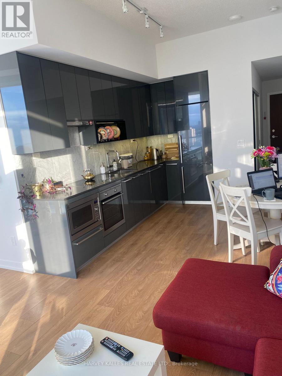 A modern kitchen with a red stool in front of it.
