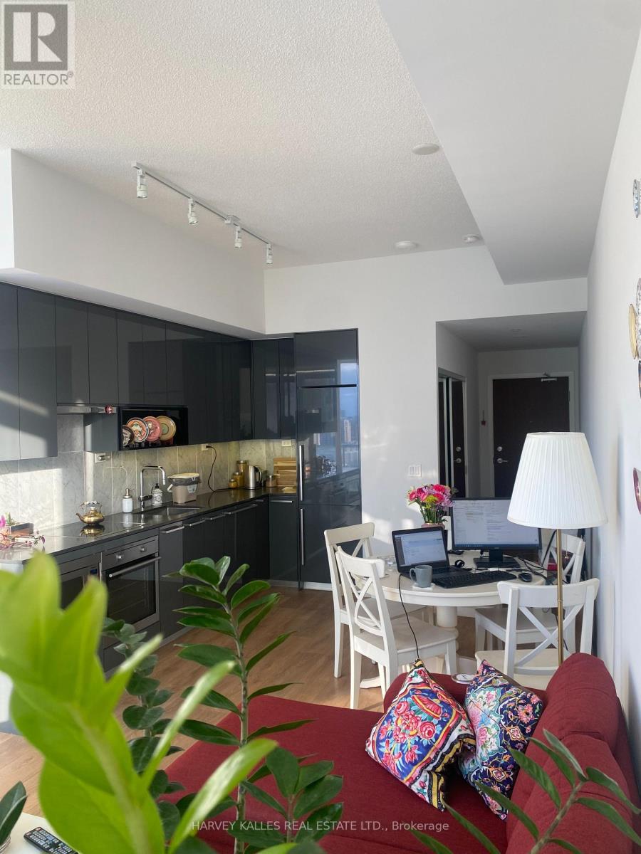 A modern kitchen with a dining area and a red couch.