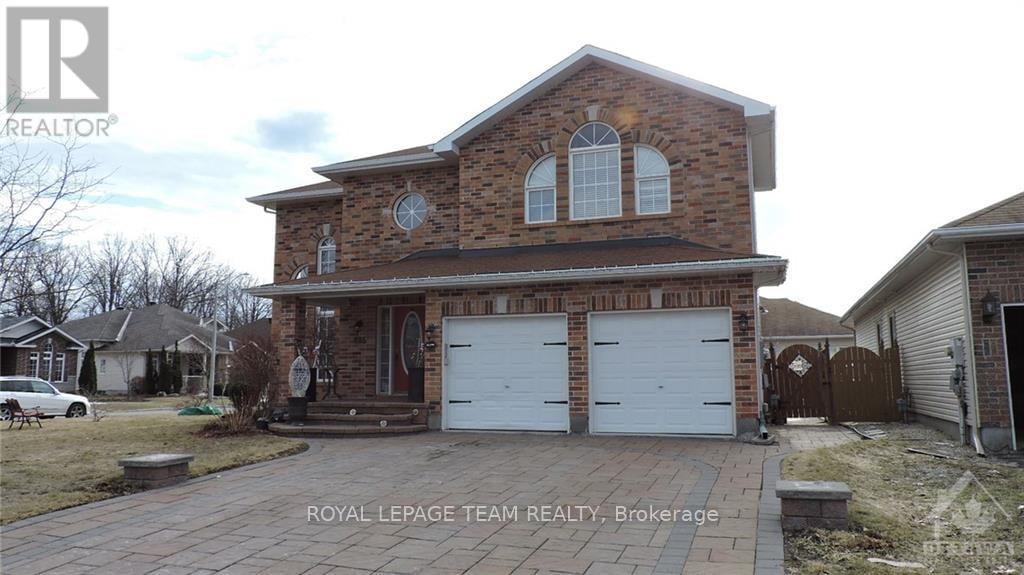 A brick house with a white garage door is for sale.