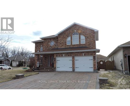 A brick house with a white garage door is for sale.