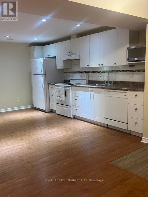 A kitchen with white cabinets and appliances.