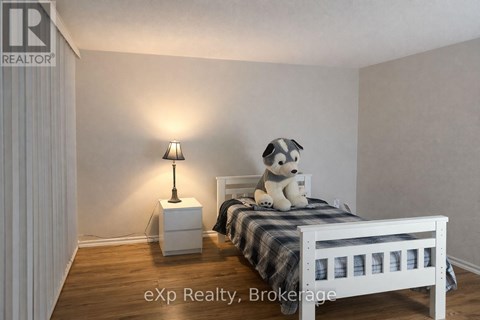 A bedroom with a bed, a lamp, and a teddy bear.