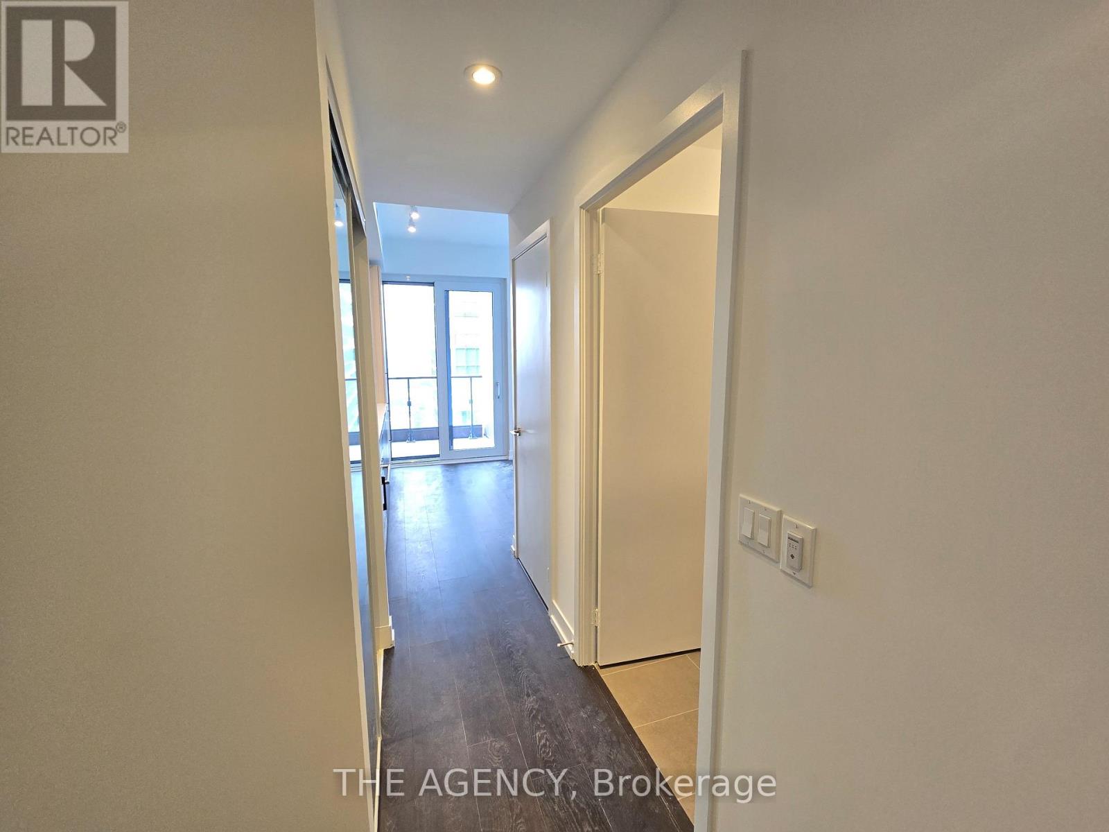 A hallway with a door on the right and a window on the left.